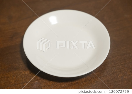 Image of a white plate on a table (stock photo) Image of a white plate on a table (stock photo) 120072759