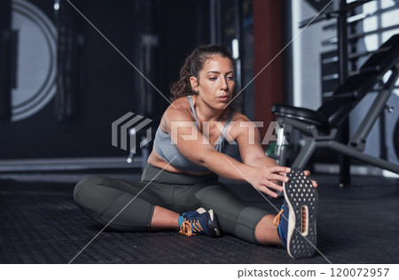 Getting her dose of fitness for the day. Shot of a sporty young woman exercising in a gym. 120072957