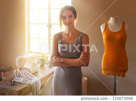Creativity is intelligence having fun. A young designer making a garment in her workplace. 120073098