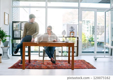 Figuring out some new plans. Shot of two businesspeople working together on a laptop in an office. Figuring out some new plans. Shot of two businesspeople working together on a laptop in an office. 120073162