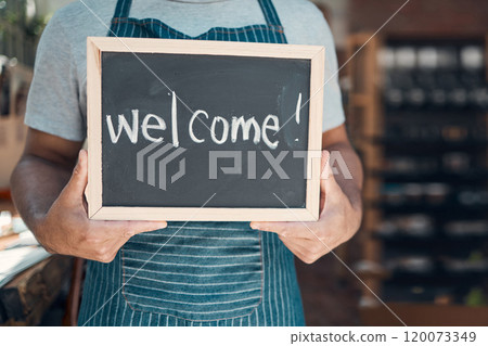 Waiter, hands and sign with welcome at cafe for hospitality, customer service and ready to start day. Barista, person and chalkboard with message at coffee shop entrance for opening at small business 120073349