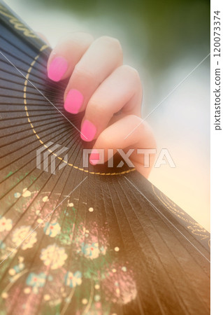 Fan, tradition and hand of woman with Asian dance, celebration or elegant costume aesthetic. Culture, ritual and person with paper pattern accessory, decoration or art for Chinese new year festival 120073374