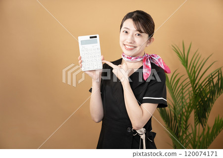 A smiling beautician holding a white calculator 120074171