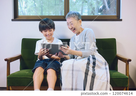 孫子和祖母在家一起享用平板電腦 孫子和祖母在家一起享用平板電腦 120074614