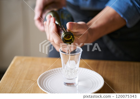 Pouring sake into a glass - tasting image 120075343