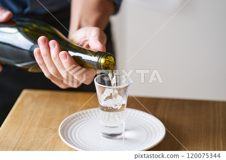 Pouring sake into a glass - tasting image 120075344