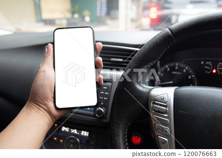 hand holding a smartphone with a blank screen inside a car, depicting the use of mobile technology for navigation or communication while driving. Transportation, mobile technology, automotive 120076663