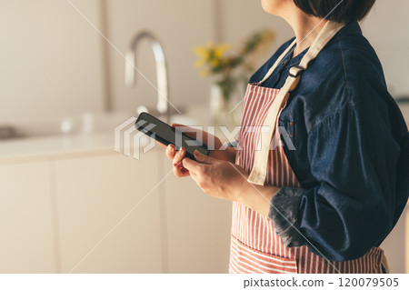 Housewife with a smartphone 120079505