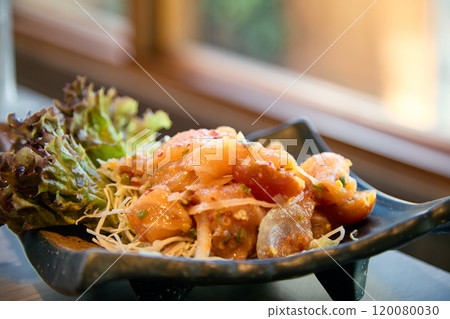 Close-up of salmon poke bowl with lettuce and shredded vegetables served in black ceramic dish Close-up of salmon poke bowl with lettuce and shredded vegetables served in black ceramic dish 120080030
