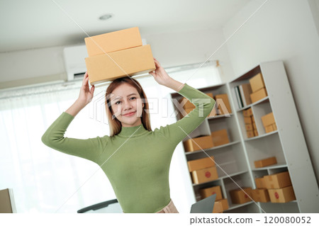 A woman is holding a stack of boxes on her head A woman is holding a stack of boxes on her head 120080052