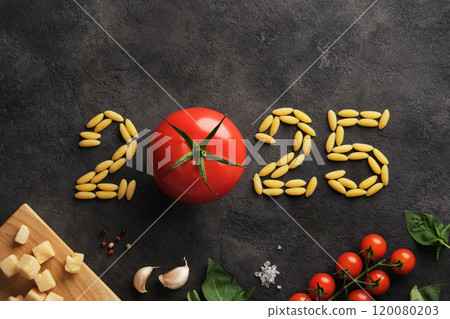 The year 2025 lined with tomatoes and pasta on a dark stone background. A culinary design for the new year. 120080203