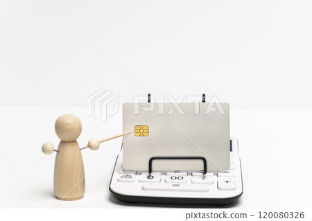 Peg doll showing a credit card on a calculator Peg doll showing a credit card on a calculator 120080326