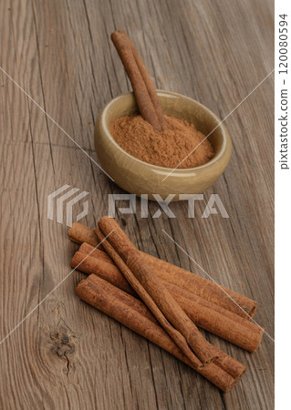 cinnamon sticks and powder on wooden table 120080594