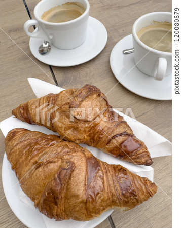 French croissants and cups of coffee on table 120080879