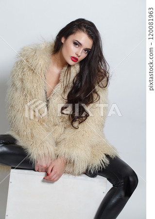 Cheerful fashion model woman with make-up wearing white faux fur coat posing Cheerful fashion model woman with make-up wearing white faux fur coat posing 120081963
