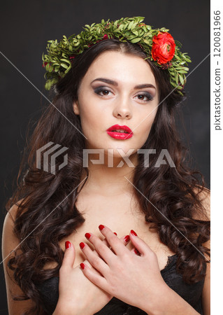 Glorious healthy female model with shiny hair, make-up and spring flower on black background 120081966