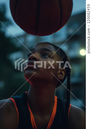 Focused Young Athlete Practicing Basketball at Dusk in Urban Environment. Ai generative Focused Young Athlete Practicing Basketball at Dusk in Urban Environment. Ai generative 120082459
