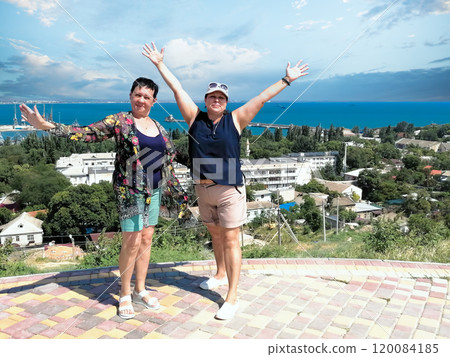 Two Women Posing on a Hill with Scenic Views of Feodosia, Crimea. 120084185