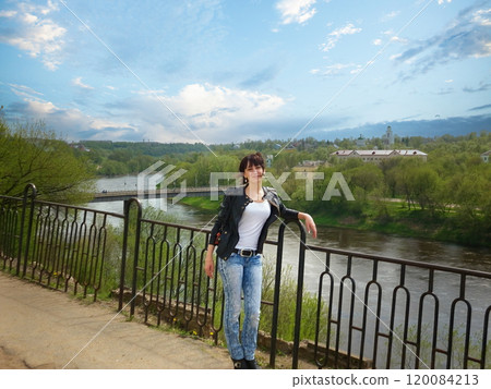 Stunning Young Woman Strikes a Pose Against Urban Backdrop. 120084213