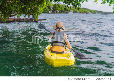 Woman kayaking on Bacalar Lake in Mexico. Adventure tourism in Quintana Roo, outdoor exploration, and water activities concept 120084451