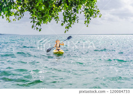 Woman kayaking on Bacalar Lake in Mexico. Adventure tourism in Quintana Roo, outdoor exploration, and water activities concept 120084733