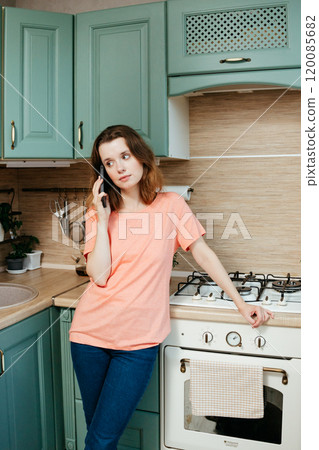 Young European woman calls on smartphone and orders food from delivery service or restaurant 120085682