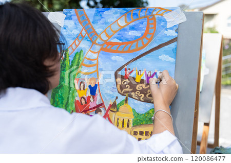 A teenage girl draws a picture outdoors. A teenage girl draws a picture outdoors. 120086477