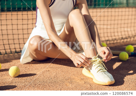 Close up picture of a tennis player tying the sneakers Close up picture of a tennis player tying the sneakers 120086574