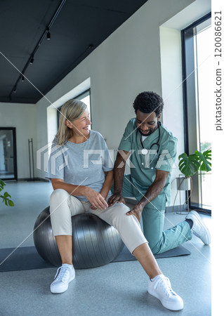 African american manual therapist working with a female patient with problematic joints 120086621