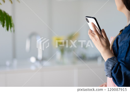 Housewife with a smartphone Housewife with a smartphone 120087915