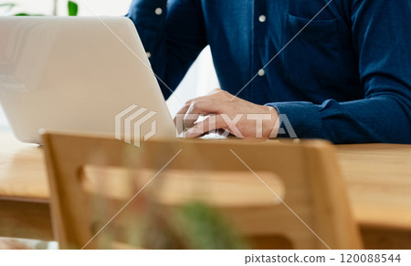 A man who uses a personal computer in the living room A man who uses a personal computer in the living room 120088544