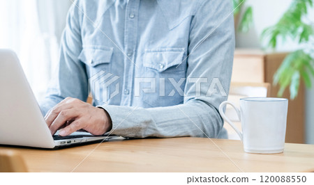 A man who uses a personal computer in the living room 120088550
