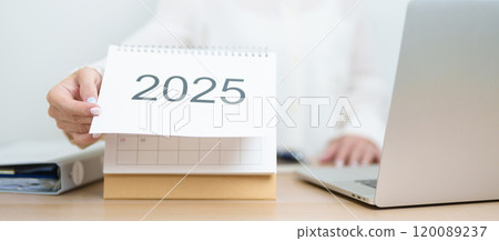 2025 Year Calendar on table with business woman using laptop computer, working and writing in office. countdown, Happy New Year, Resolution, Year End and New Start and Goals Plan Action Concept 2025 Year Calendar on table with business woman using laptop computer, working and writing in office. countdown, Happy New Year, Resolution, Year End and New Start and Goals Plan Action Concept 120089237
