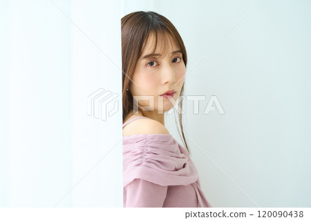 A young woman standing by the window 120090438