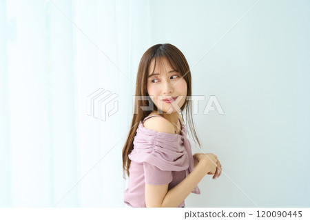 A young woman standing by the window A young woman standing by the window 120090445