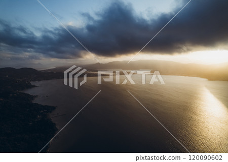 Overcast view of tranquil lake surrounded by mountains and distant coastline 120090602