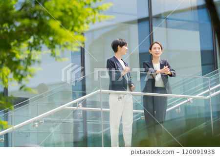 Two women smiling in front of an office Two women smiling in front of an office 120091938