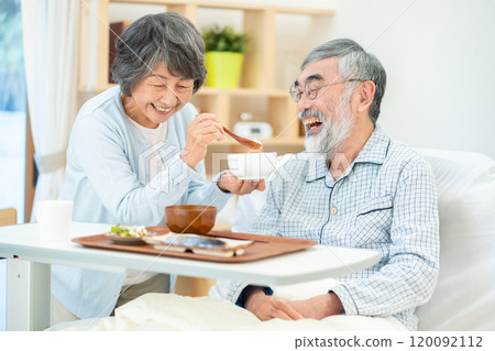 Senior woman feeding her husband 120092112