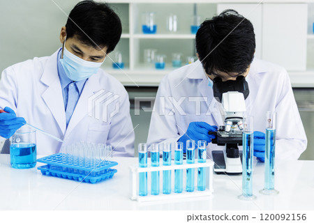Scientist man look into Microscope research in science laboratory. Asian scientist looking equipment laboratory chemistry labs. Covid-19 coronavirus biochemistry research experiment vaccine concept 120092156