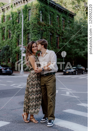 A couple joyfully embracing each other in a vibrant urban setting, surrounded by lush greenery A couple joyfully embracing each other in a vibrant urban setting, surrounded by lush greenery 120092220