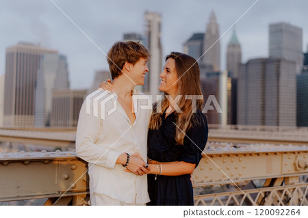 A Romantic Couple Deeply Embracing Each Other on the Beautiful Brooklyn Bridge at Dusk 120092264