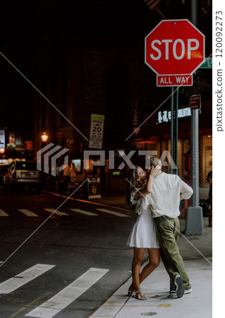 A Romantic and Enchanting Nighttime Urban Couple Embraces Tenderly at a Busy Crosswalk A Romantic and Enchanting Nighttime Urban Couple Embraces Tenderly at a Busy Crosswalk 120092273