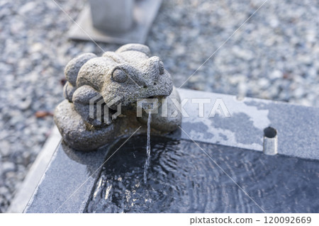 A frog at Kaeru Shrine pouring water into the Chozuya (purification fountain) 120092669