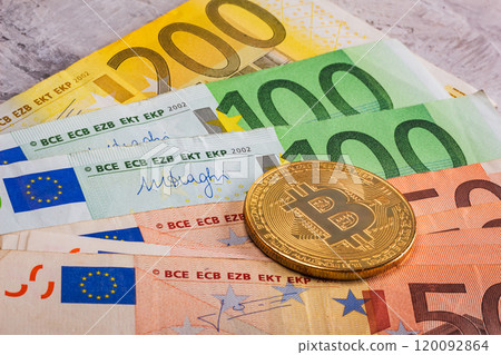 A Varied Collection of Euro Banknotes Alongside a Single Bitcoin Coin Showcased on a Table Surface A Varied Collection of Euro Banknotes Alongside a Single Bitcoin Coin Showcased on a Table Surface 120092864