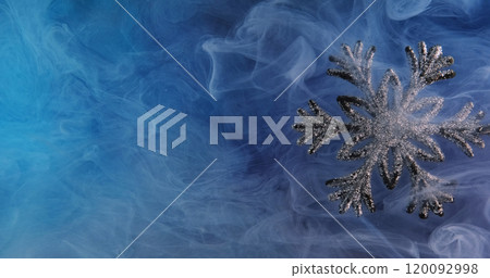 Glitter mist. Snowflake background. Blue color paint water smoke cloud revealing shimmering silver decoration. Glitter mist. Snowflake background. Blue color paint water smoke cloud revealing shimmering silver decoration. 120092998