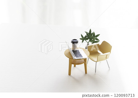 A table and chair with a miniature laptop on it 120093713