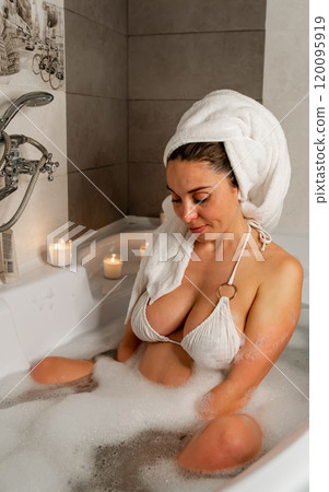 Pregnant woman relaxing in bubble bath 120095919