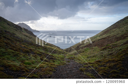 Islandic landscape with bay and ships with thick storm clouds above them, Madeira, Portugal 120095968