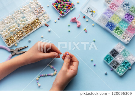 Creating colorful beaded jewelry with vibrant materials on a crafting table 120096309