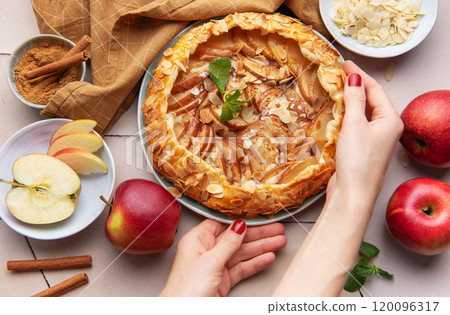 Apple galette preparation with fresh ingredients and spices on a kitchen countertop 120096317